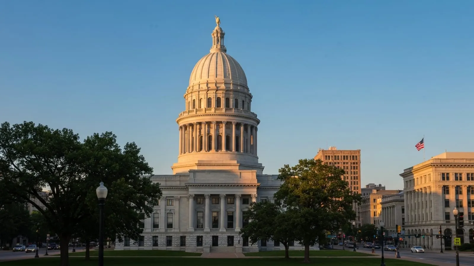 Editorial photograph of the historic Illinois State Capitol building dome in Springfield Illinois at golden hour with the limestone neoclassical facade catching warm light.