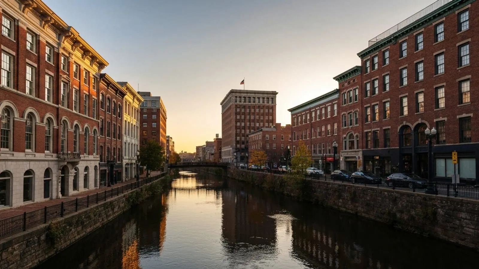 Editorial photograph of Continental Square in downtown York at golden hour with the historic 19th-century brick architecture and the Codorus Creek visible in the background.