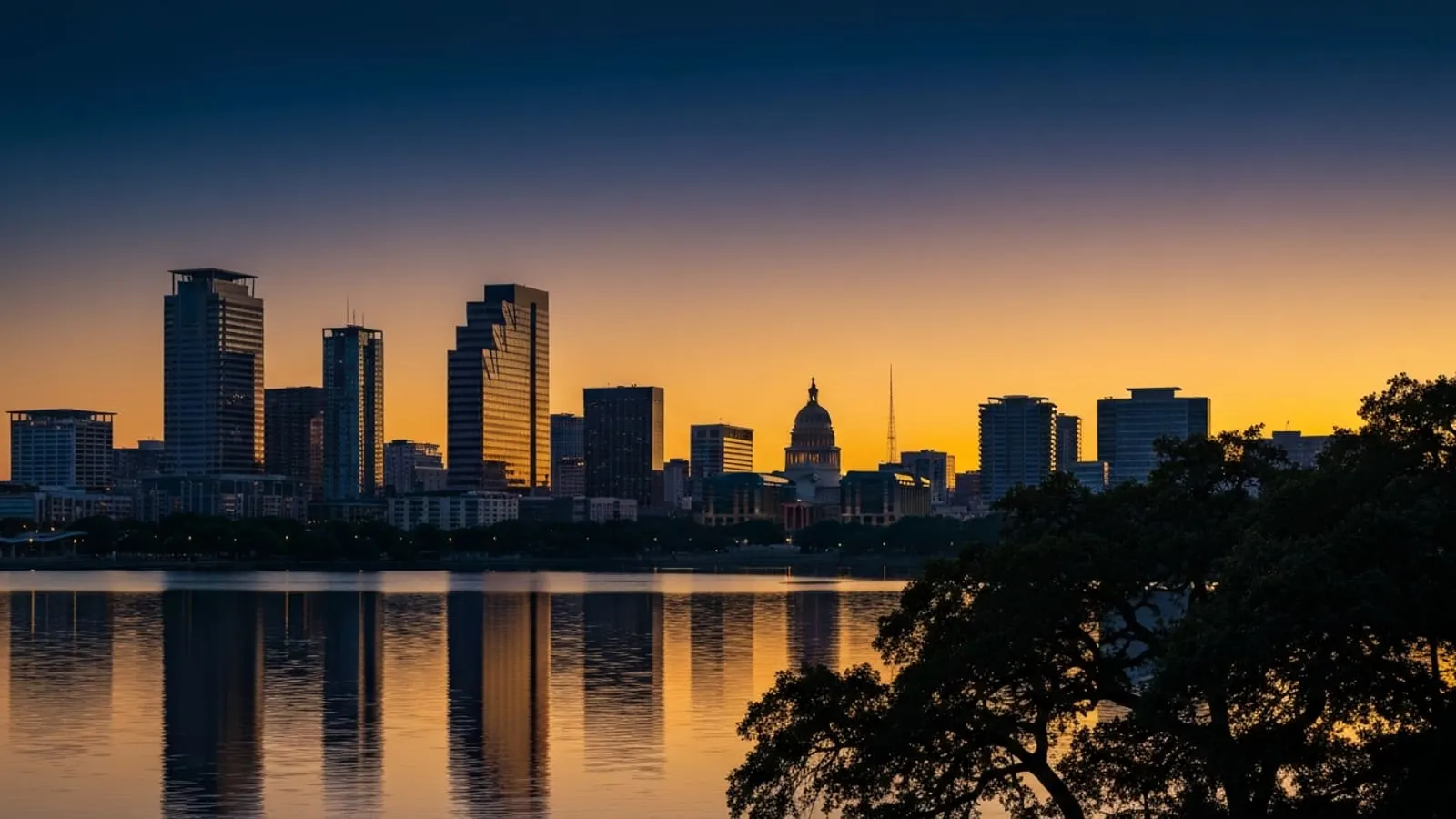 Austin downtown skyline at dusk with the Frost Bank Tower and the Texas State Capitol visible across Lady Bird Lake