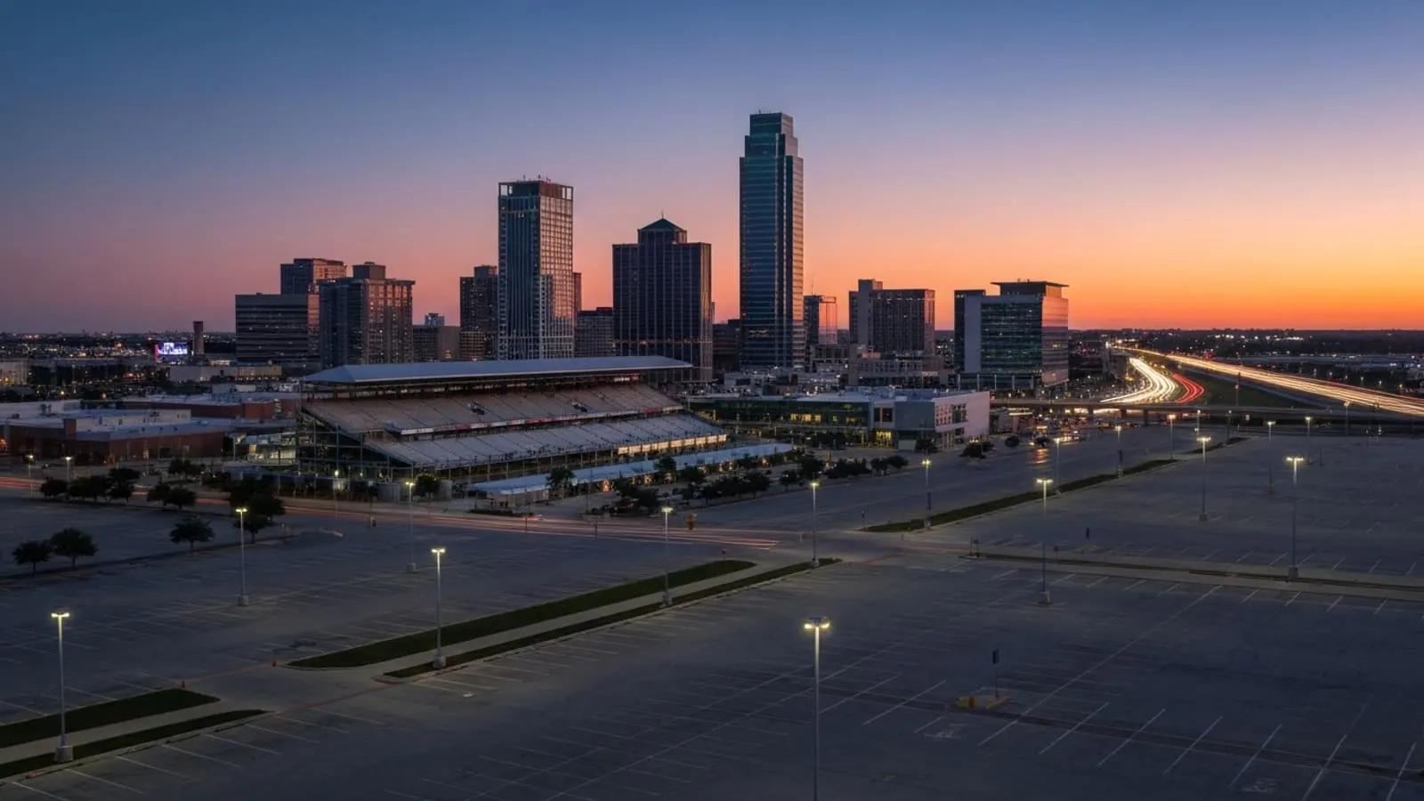 Lone Star Park grandstand at sunset with the Grand Prairie skyline and modern entertainment district in the background