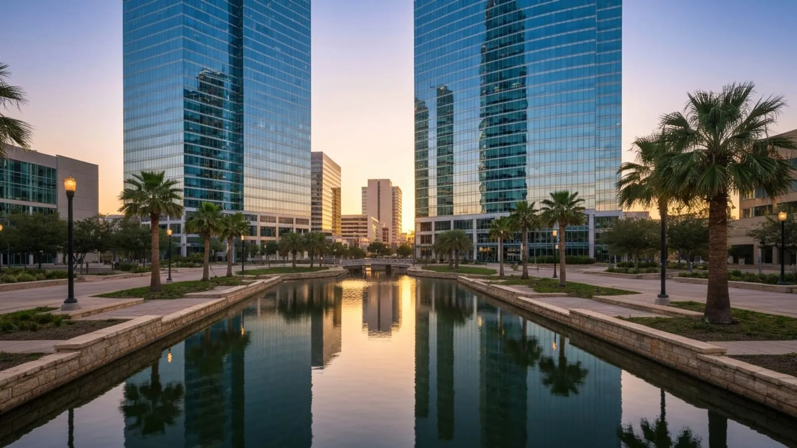 Las Colinas Mandalay Canal in Irving at golden hour with the Mustangs of Las Colinas sculpture and modern office towers in the background